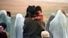 Afghanistan -- Afghan refugees walk along the road fleeing fighting north of Kabul October 11