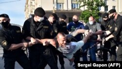 Belarus' riot police officers detain an opposition supporter during a gathering to support candidates seeking to challenge President Alyaksandr Lukashenka.
