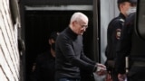  Russian historian Yury Dmitriyev, who was charged with sexually abusing his adopted daughter, is escorted by police officers after a court hearing in Petrozavodsk, Russia on July 22, 2020.